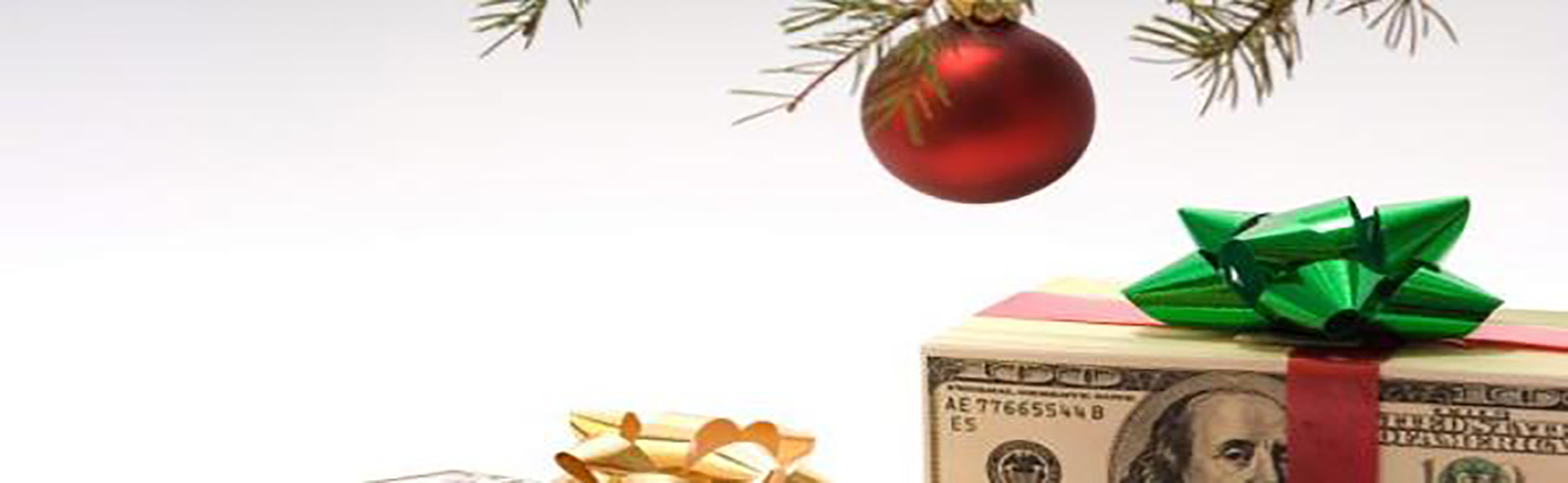Money with a bow on top, under a Christmas tree